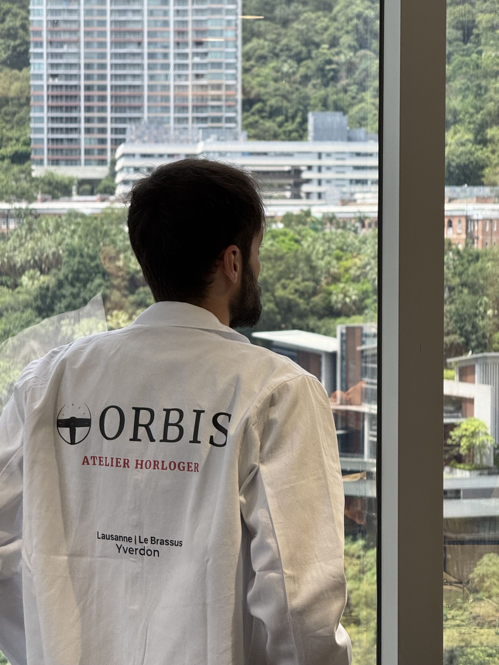 Horloger ORBIS en blouse devant la skyline de Hong Kong